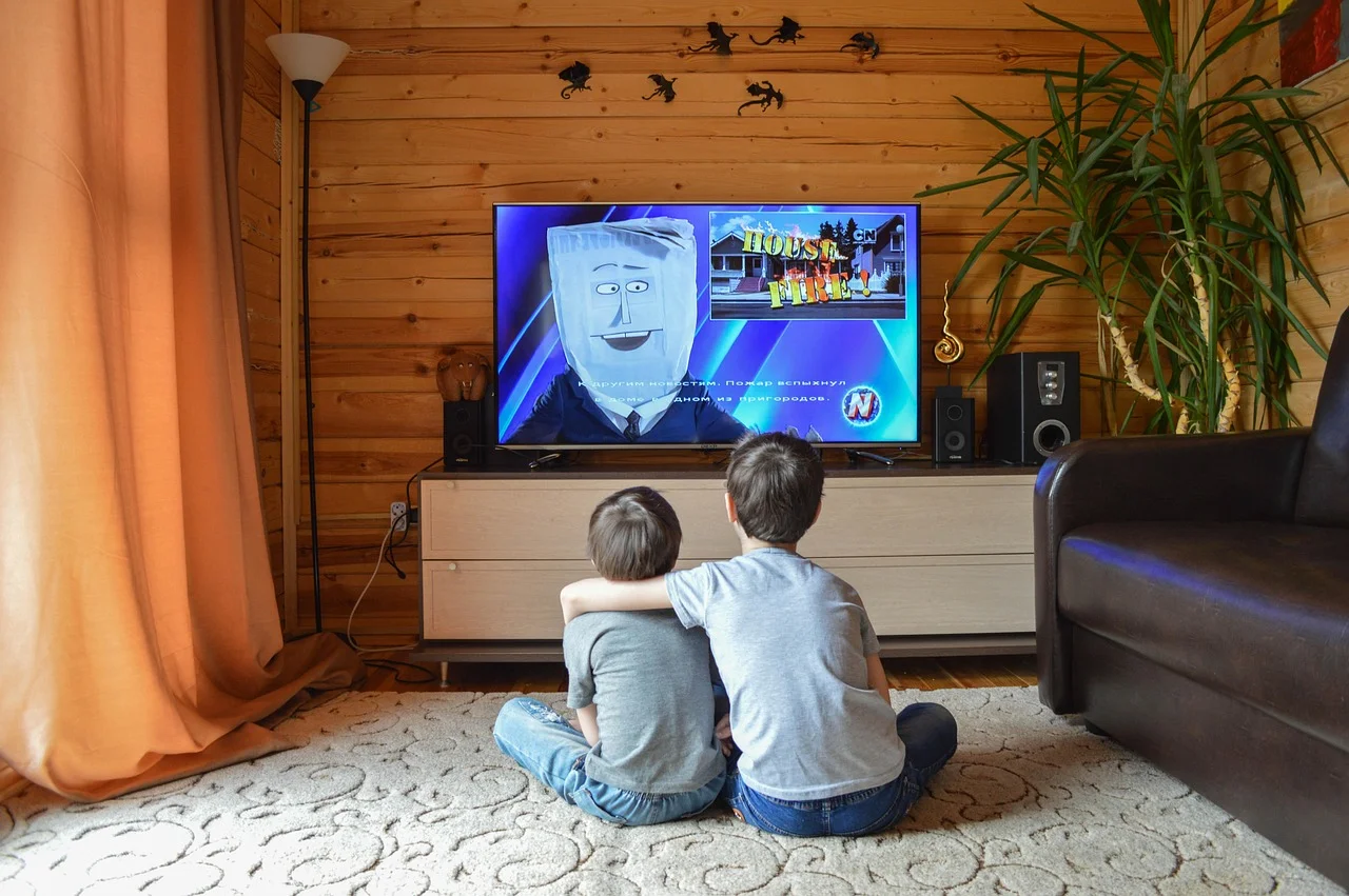 Two children watching television together in a living room